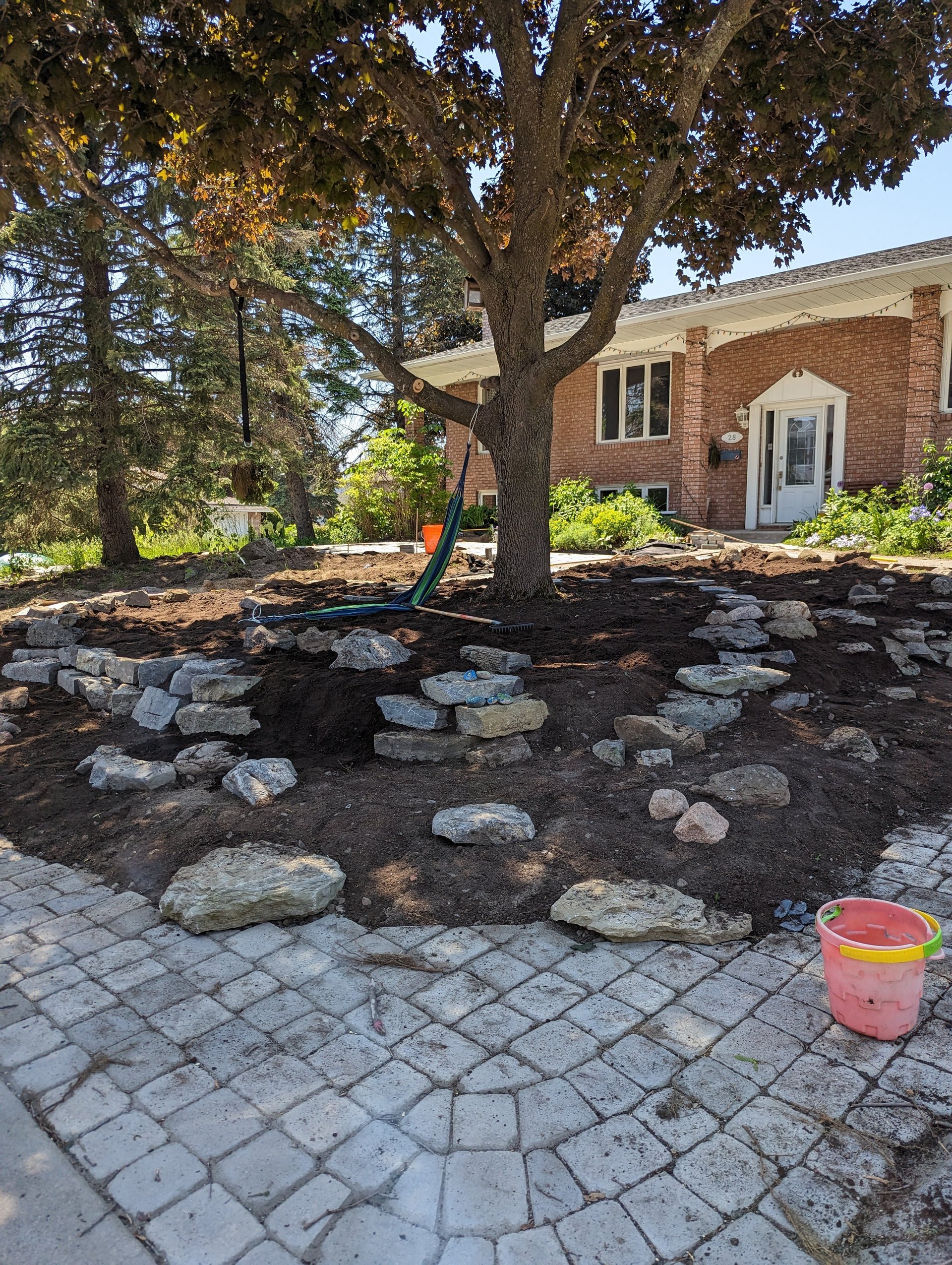 Pavers were laid along the right of way, and we placed rocks somewhat randomly to form the foundation of the rock garden